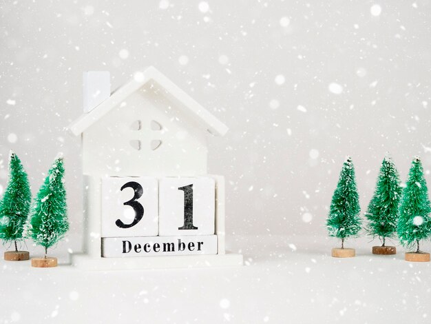 Calendario de madera con un árbol de Navidad con la fecha 31 de diciembre sobre un fondo claro El concepto del Año Nuevo