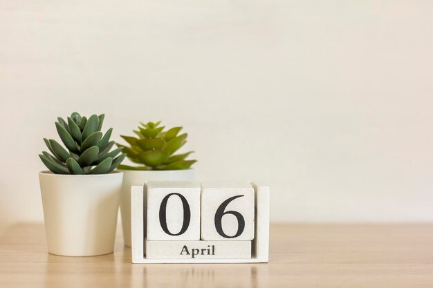 Un calendario de madera con la fecha del 6 de abril en el escritorio.