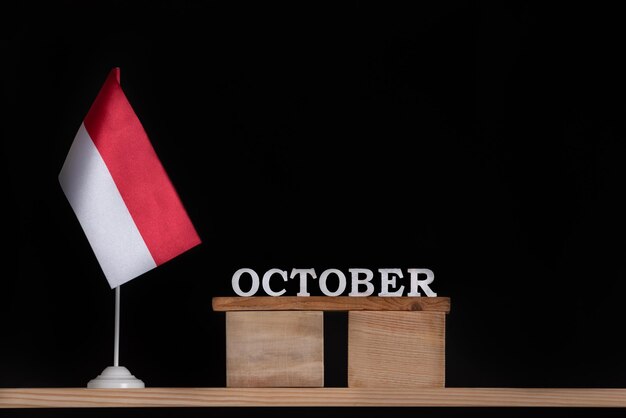 Calendario de madera de octubre con bandera polaca sobre fondo negro. Fiestas de Polonia en octubre.