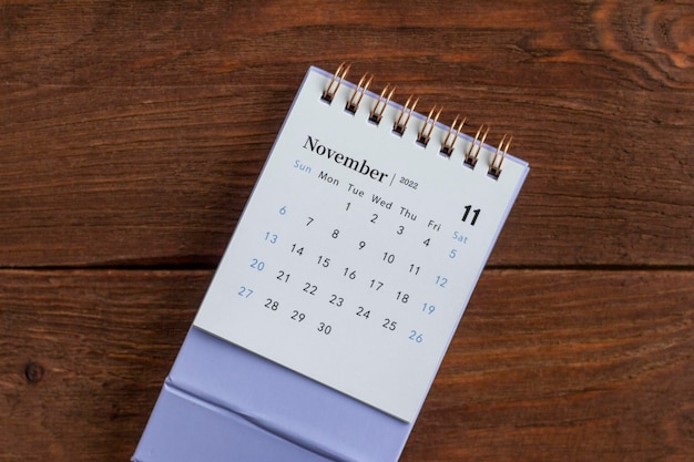 Calendario mensual de escritorio para noviembre de 2022 sobre un fondo de madera oscura