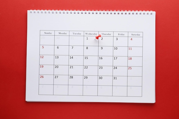 Calendario de planificación con pin 1Ñ… Sobre fondo rojo. Fecha importante. Lugar para el texto. Concepto de planificación.