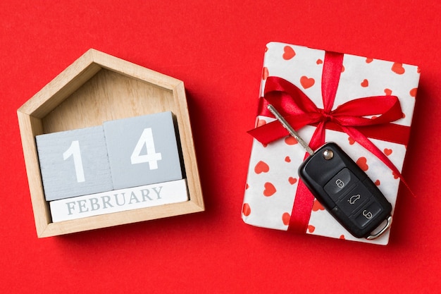 Calendario de San Valentín y caja de regalo con cinta roja y llave de coche. Endecha plana