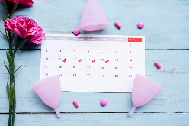 Foto calendario con tazas de rosas y pastillas para el dolor