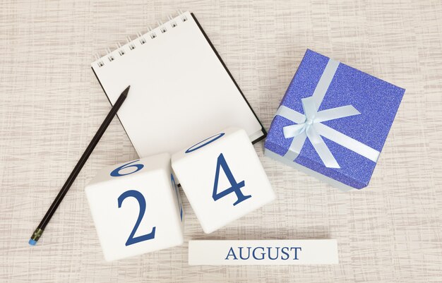 Calendario con texto azul moderno y números para el 24 de agosto y un regalo en una caja.