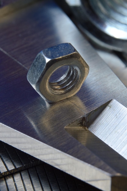 El calibrador de la herramienta de medición precisa y la regla de metal se encuentran en su lugar con las tuercas cerradas
