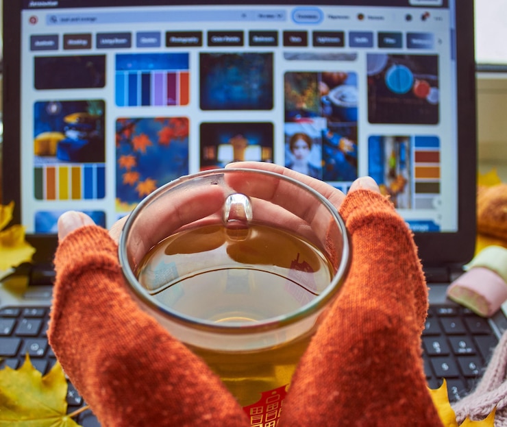 Foto cálida taza de té bufanda hojas amarillas malvavisco y computadora portátil acogedor hogar independiente en línea estudiando educación concepto de trabajo remoto vista superior copiar espacio
