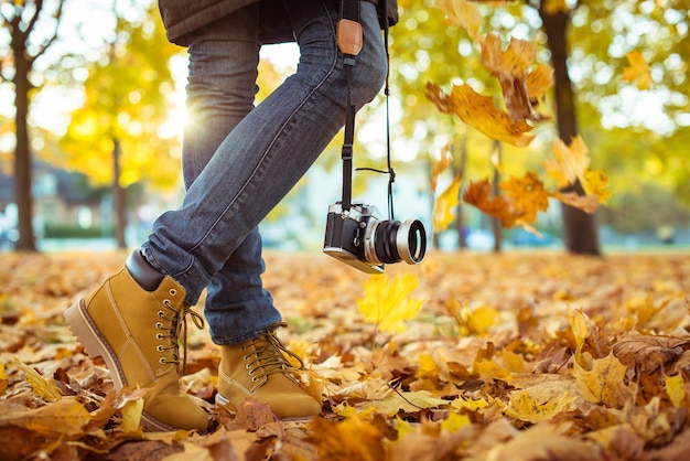 Cálidas botas amarillas Caminando en hojas de otoño