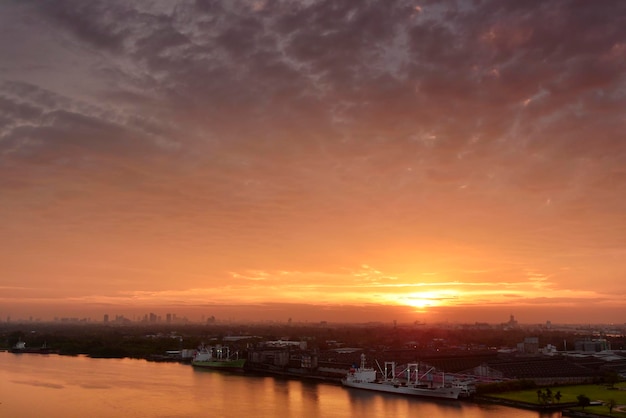 Cálido cielo crepuscular de la ciudad y un río en una mañana