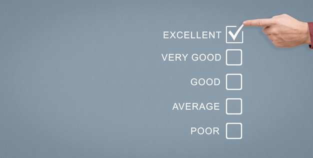 Calificación excelente Encuesta de calidad que brinda una excelente calificación de retroalimentación en oposición a las calificaciones Bueno, Promedio y Pobre, la mano con lápiz calificará como excelente en el espacio de copia del formulario de encuesta