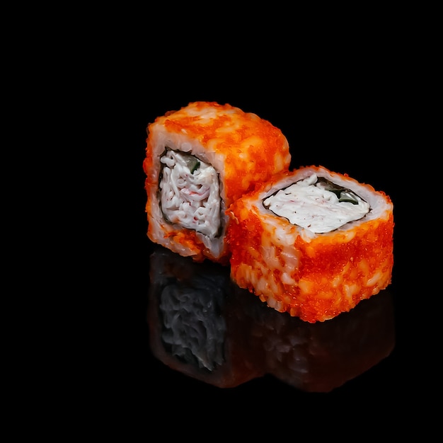 California Rolls mit Nori, Gurke, Masago, Krabbenfleisch auf schwarzem Hintergrund mit Reflexion isoliert. Sushi Kalifornien.