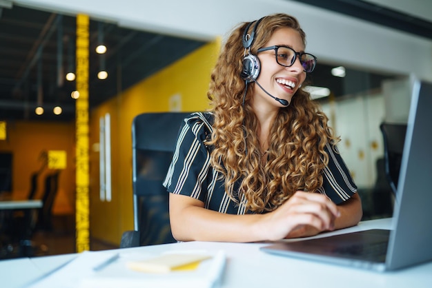 Foto call-center-agent mit headset, der an der support-hotline in modernen büro-videokonferenzen arbeitet