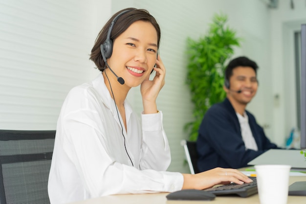 call center asiática mujer agente sonriente trabajando en sala de operaciones en la mesa de escritorio