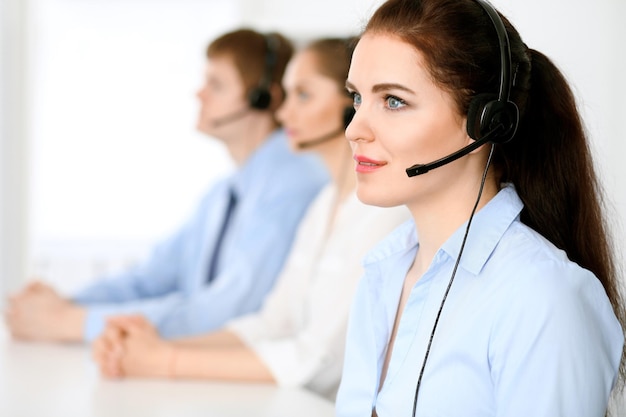 Call-Center-Betreiber. Fokus auf brünette Geschäftsfrau im Headset