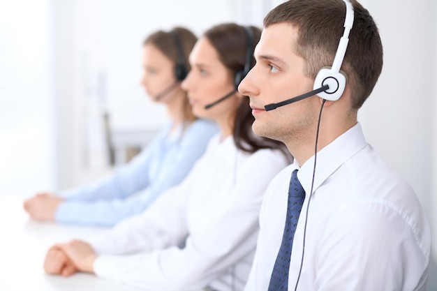 Call-Center-Betreiber. Konzentrieren Sie sich auf den Geschäftsmann im Headset, während Sie Kunden beraten.
