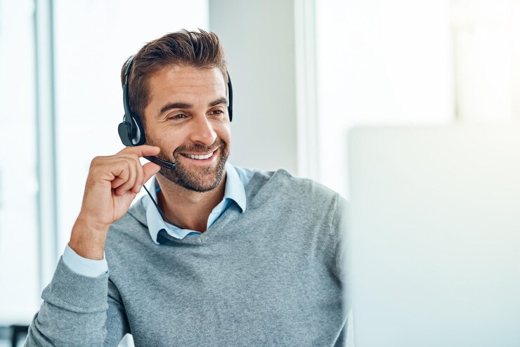 Foto call-center-crm und kundenbetreuungsberatung mit einem lächeln beim internet-telemarketing-verkauf in einem agenturbüro. junger computer und glücklicher männlicher mitarbeiter, der im support-service für ratschläge arbeitet