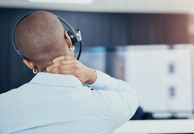 Call center de mulher negra ou CRM com estresse de dor no pescoço ou consultor de esgotamento no escritório com fones de ouvido Suporte ao cliente de atendimento ao cliente ou consultor de vendas com lesão por ansiedade ou saúde mental