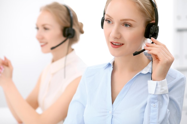 Call center Foco na linda mulher loira no fone de ouvido