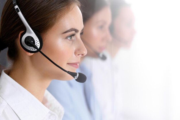 Call Center. Gruppe von Bedienern bei der Arbeit. Konzentrieren Sie sich auf die schöne Geschäftsfrau im Headset.