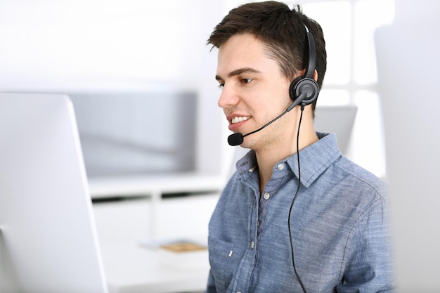 Call Center. Konzentrieren Sie sich auf die Rezeptionistin des jungen Mannes im Headset beim Kundendienst