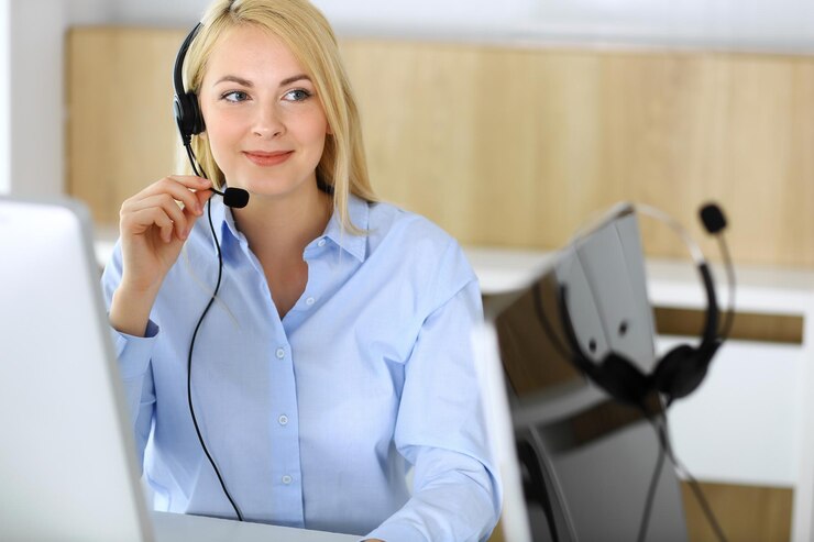 Foto callcenter blonde geschäftsfrau, die im kundendienstbüro im kopfhörer sitzt