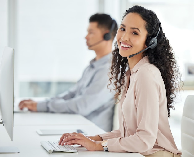 Callcenter-Lächeln und Porträt einer Frau an einem Computer für Online-Support-Beratung oder Kommunikation. Gerne kontaktieren Sie uns und einen Kundenbetreuer, der an einem PC für eine Telemarketing-Beratung tippt