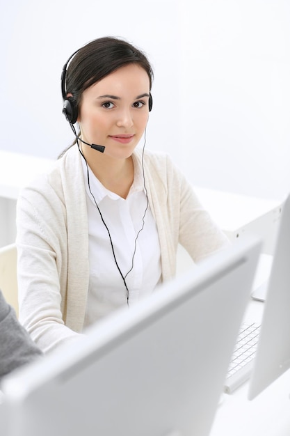 Callcenter Schöne Empfangsdame, die im Kundendienstbüro im Headset sitzt