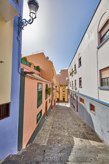 Calle angosta con casas coloridas y un cielo azul Arquitectura de un pequeño paseo entre edificios de casas antiguas Carril vacío en una hermosa ciudad para explorar y hacer turismo Santa Cruz de La Palma