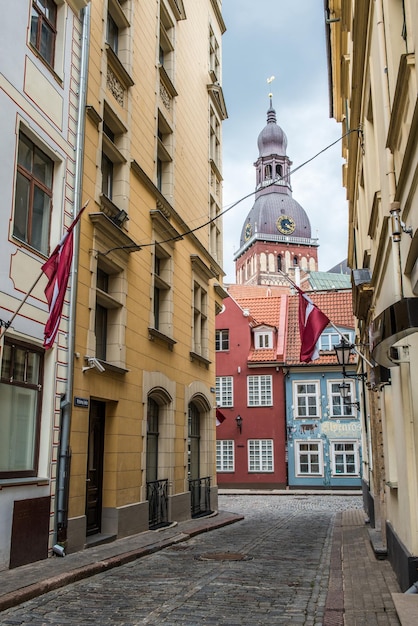 Calle angosta que conduce a la cúpula de la catedral de riga en letonia verano