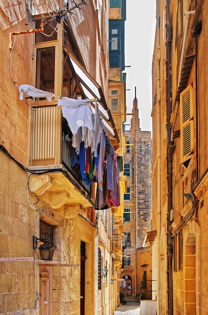 Calle antigua con casas tradicionales y balcones en el centro de la ciudad de Valletta, Malta