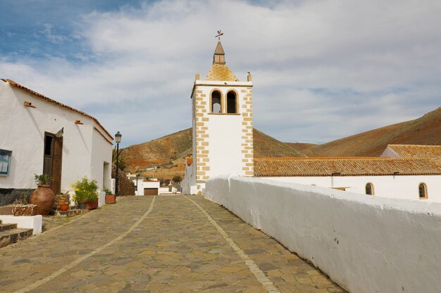 Calle con campanario de la iglesia de Santa María de Betancuria en la aldea de Betancuria en Fuerteventura, España