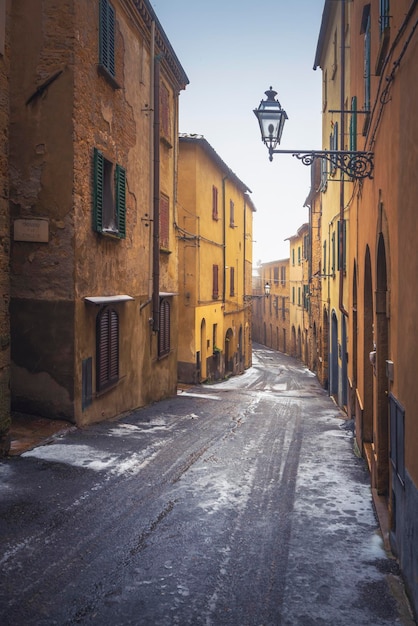 Calle del casco antiguo de Volterra durante una nevada en invierno Toscana Italia