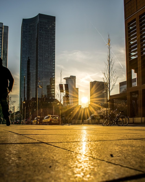 Foto calle de la ciudad por los edificios contra el cielo durante la puesta del sol