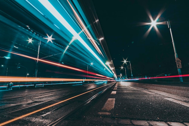 Calle de la ciudad por la noche con senderos de luz de vehículos