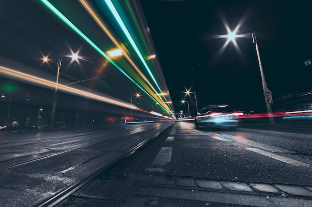 Calle de la ciudad por la noche con senderos de luz de vehículos