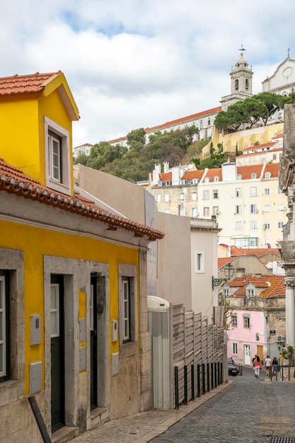Foto una calle con edificios antiguos en las laderas de una colina en la zona histórica de lisboa en portugal