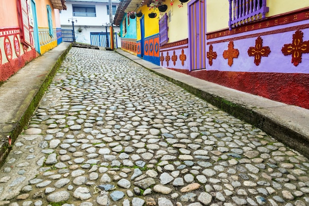 Foto calle empedrada en medio de casas de varios colores en la ciudad