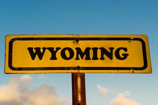 Calle del estado de Wyoming en viejo cartel amarillo con cielo azul