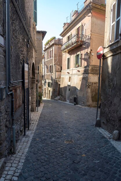 Una calle estrecha en la ciudad de Roma el camino de adoquines y casas antiguas