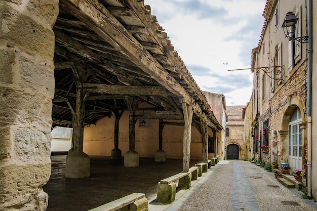 Calle estrecha, fachada antigua y mercado medieval en el pueblo de Fanjeaux, en el sur de Francia.