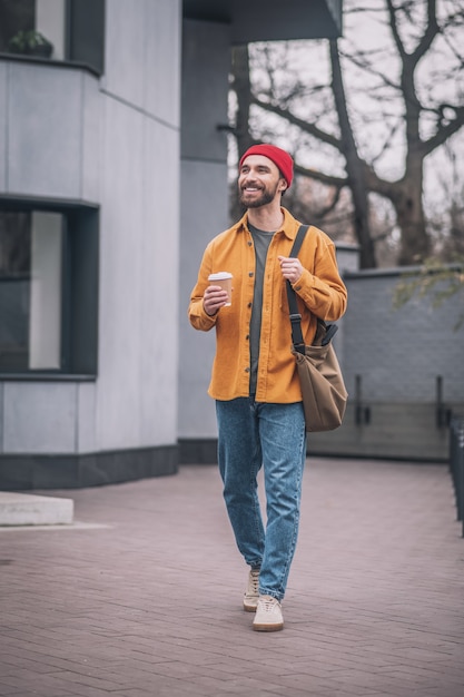 En la calle. Hombre con una chaqueta naranja caminando por la calle