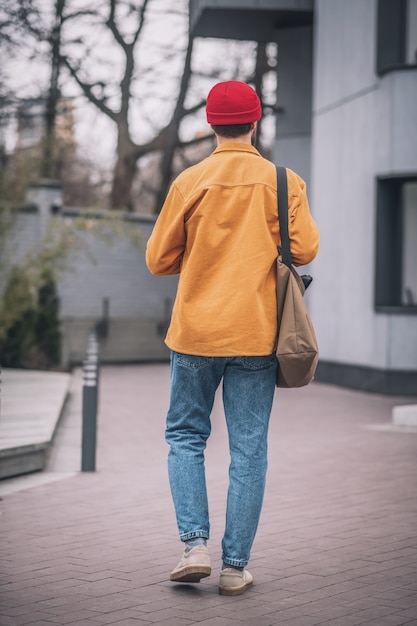 En la calle. Hombre con una chaqueta naranja caminando por la calle