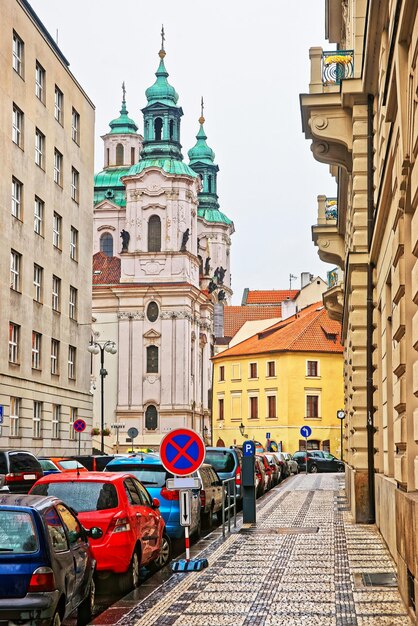 Calle con la iglesia de San Nicolás en Lesser Town Square en Praga, República Checa