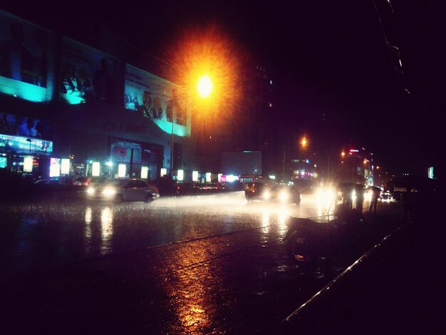 Calle iluminada de la ciudad por la noche durante el monzón