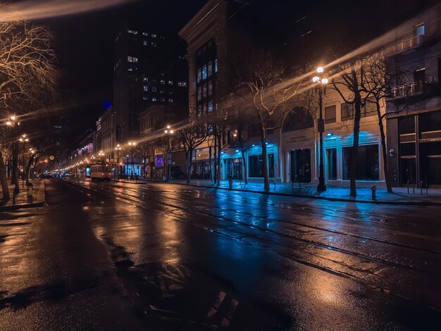 Foto calle iluminada en medio de edificios en la ciudad por la noche