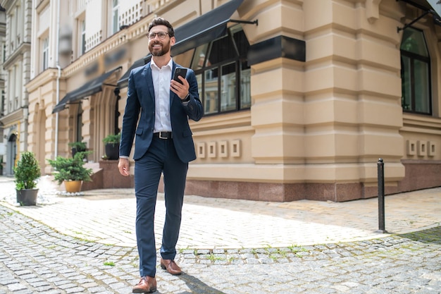 Foto en la calle. un joven apuesto con traje caminando por la calle