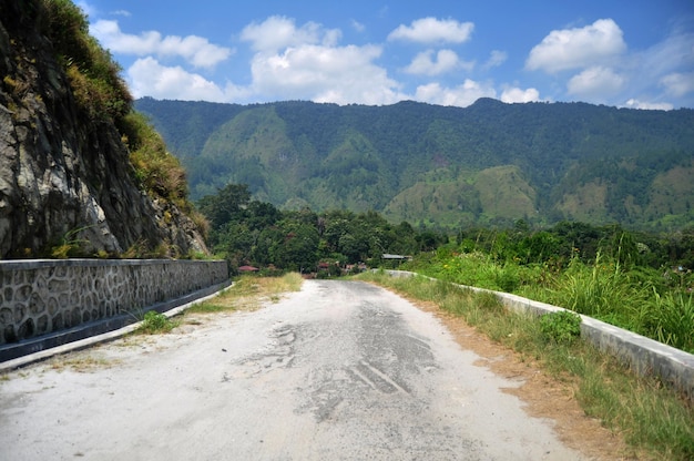 La calle local va a las montañas Sipiso Piso al lado del lago Danau Toba y Tao Batak Toba Caldera Supervolcano en la ciudad de Simanindo de la isla de Samosir en Sumatera Utara o Sumatra del Norte Indonesia
