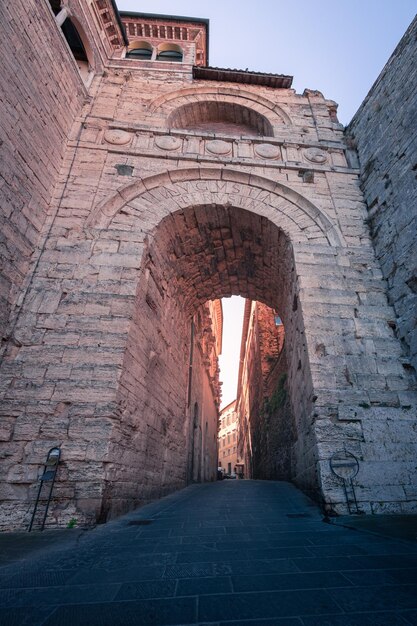 Calle medieval vacía que entra en las murallas fortificadas de la vieja ciudad europea con en un día soleado Perugia Italia