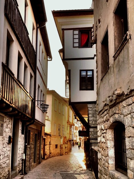 Foto calle en medio de casas contra el cielo