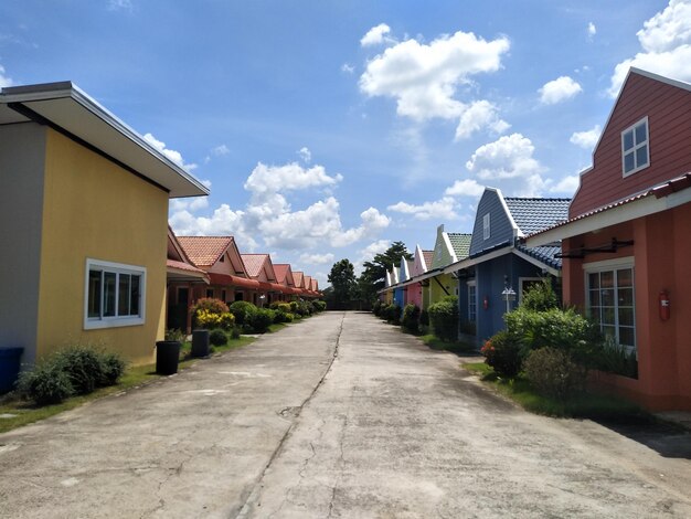 Foto calle en medio de casas y edificios contra el cielo