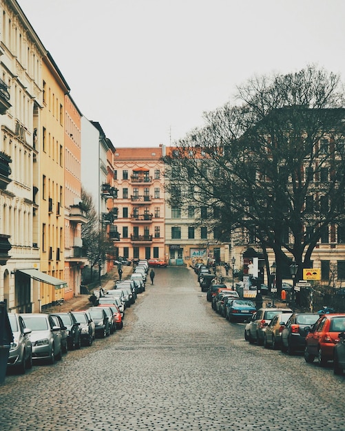 Foto calle en medio de coches contra un cielo despejado